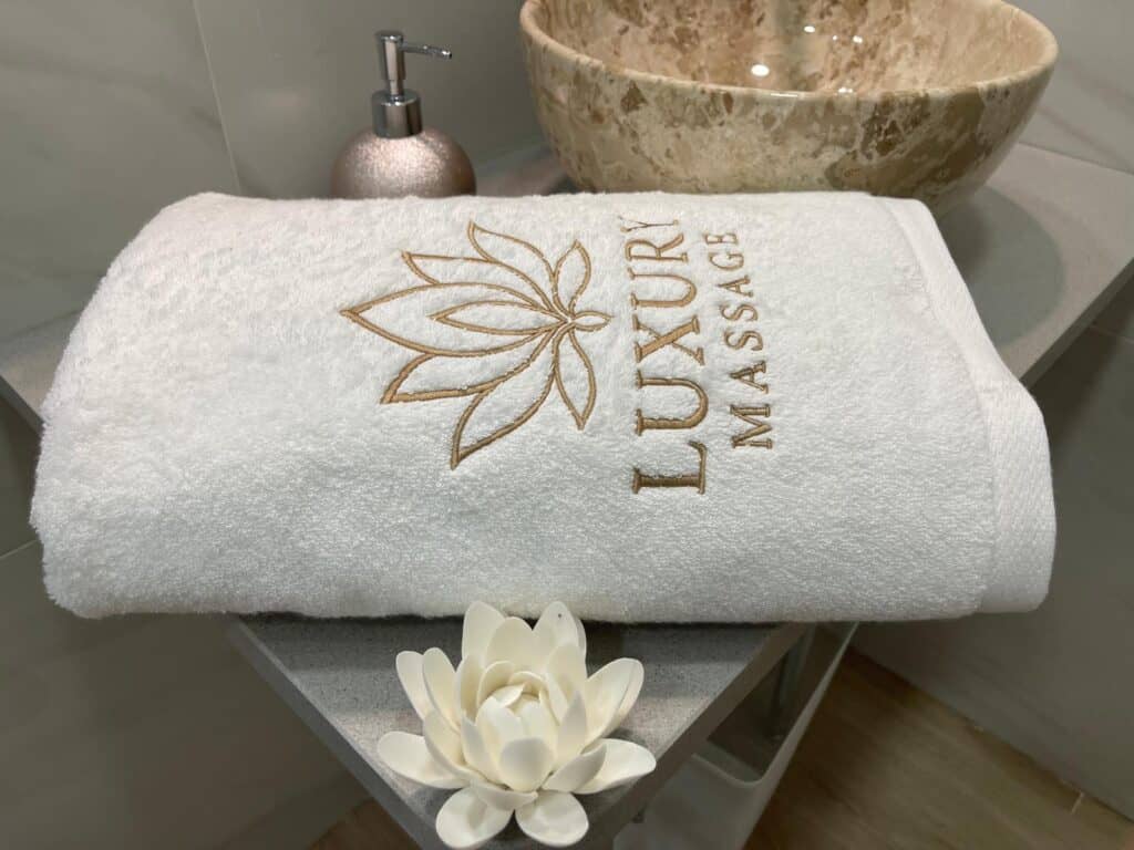Toalla blanca bordada spa con flor decorativa