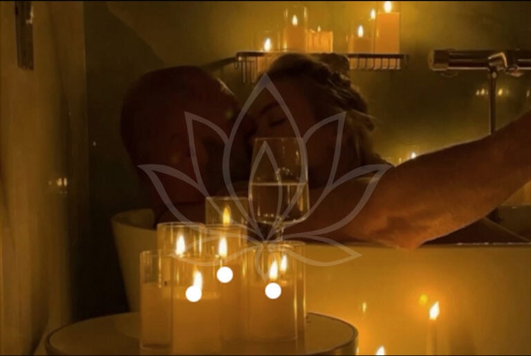 Pareja relajándose en bañera con velas encendidas